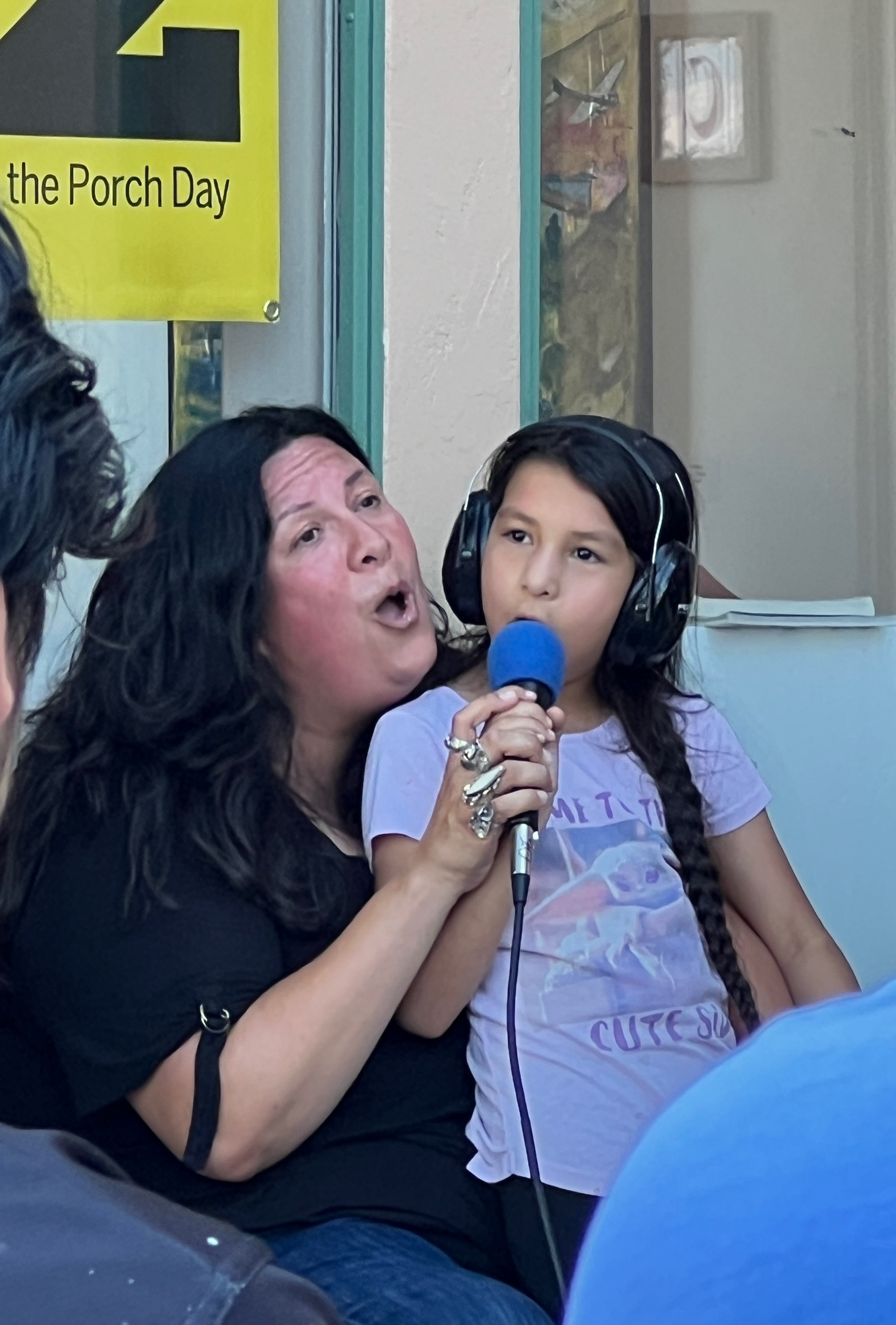 Singer and child sharing a microphone at Play Music on the Porch Day
