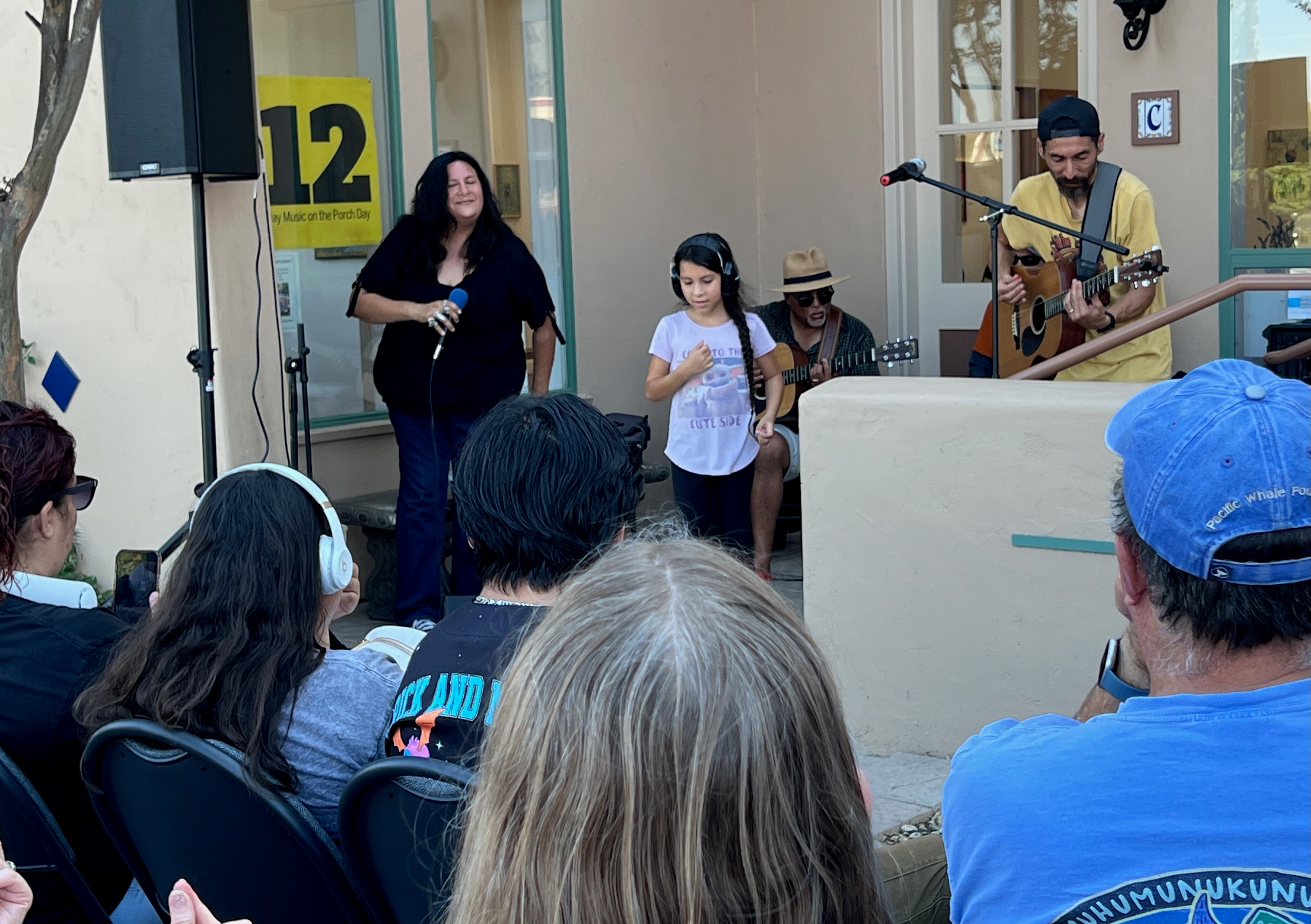Singer performing with band and young musician at Play Music on the Porch Day