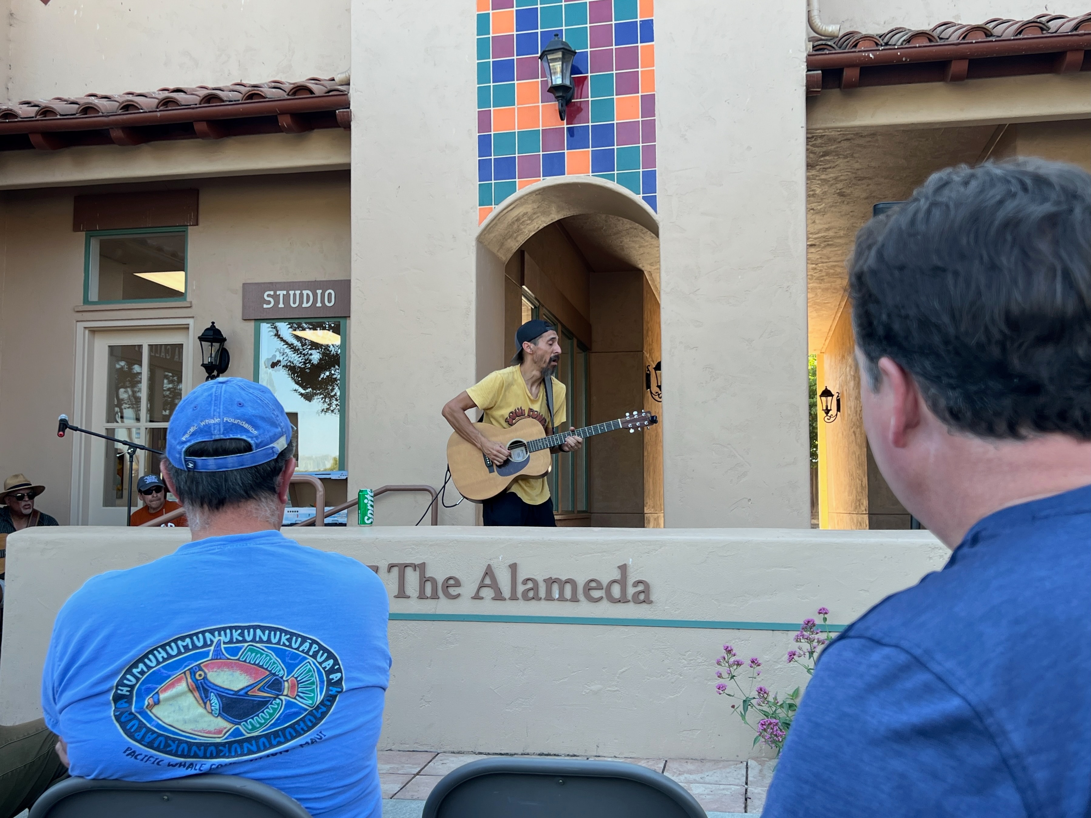 Guitarist performing at The Alameda colorful tiled wall