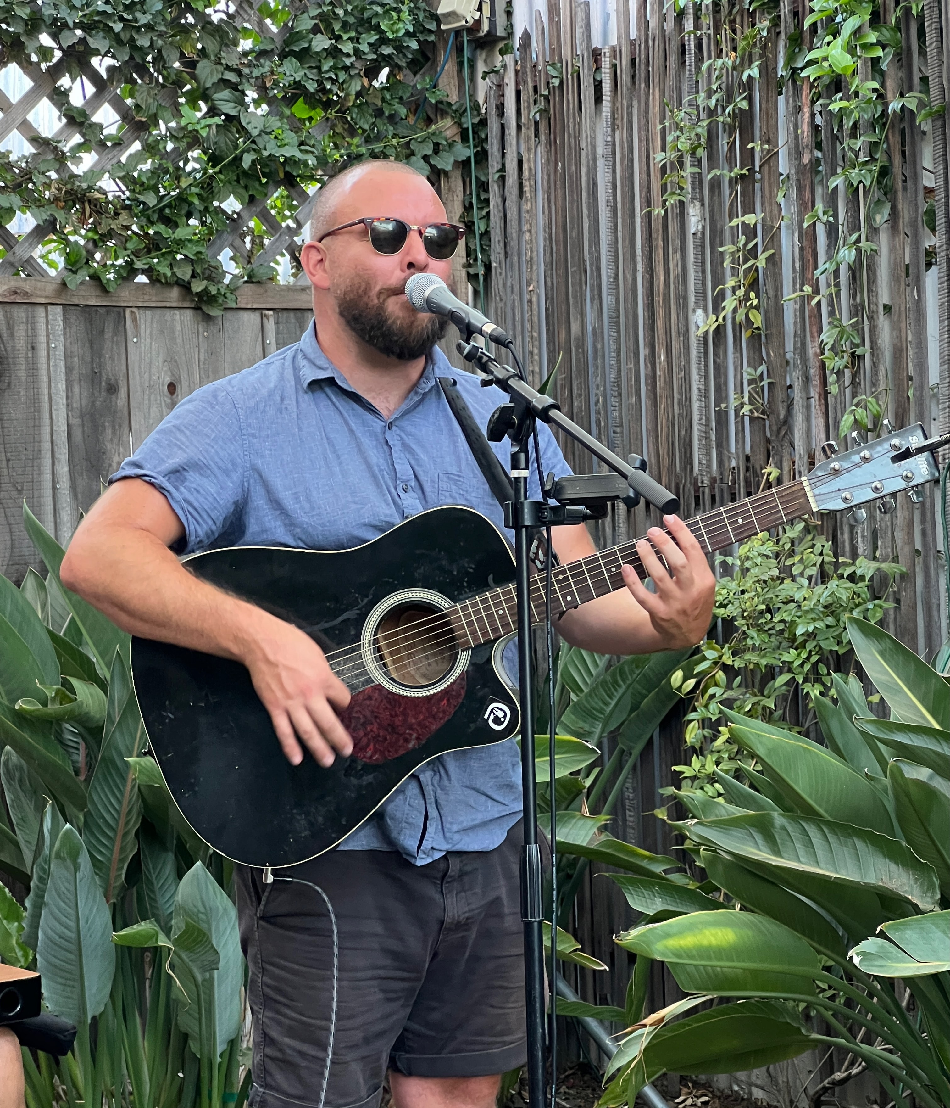 Guitarist performing acoustic set in garden