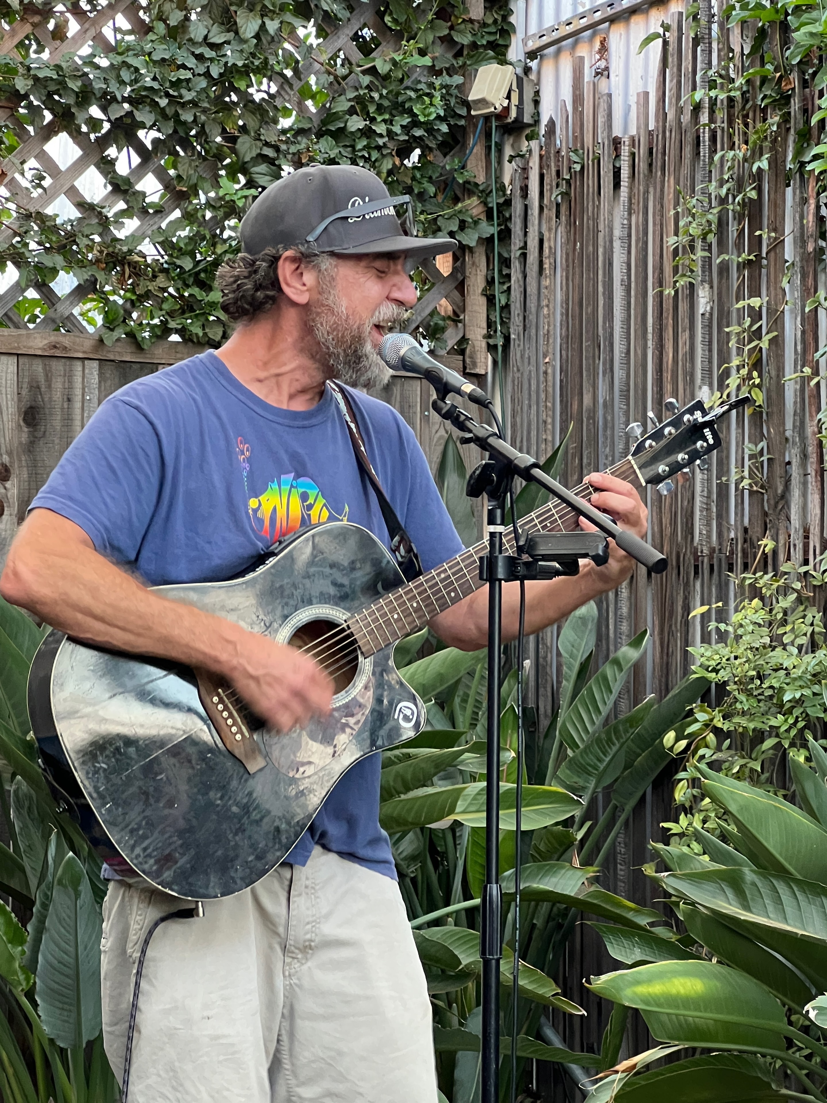 Guitarist performing in a lush garden setting