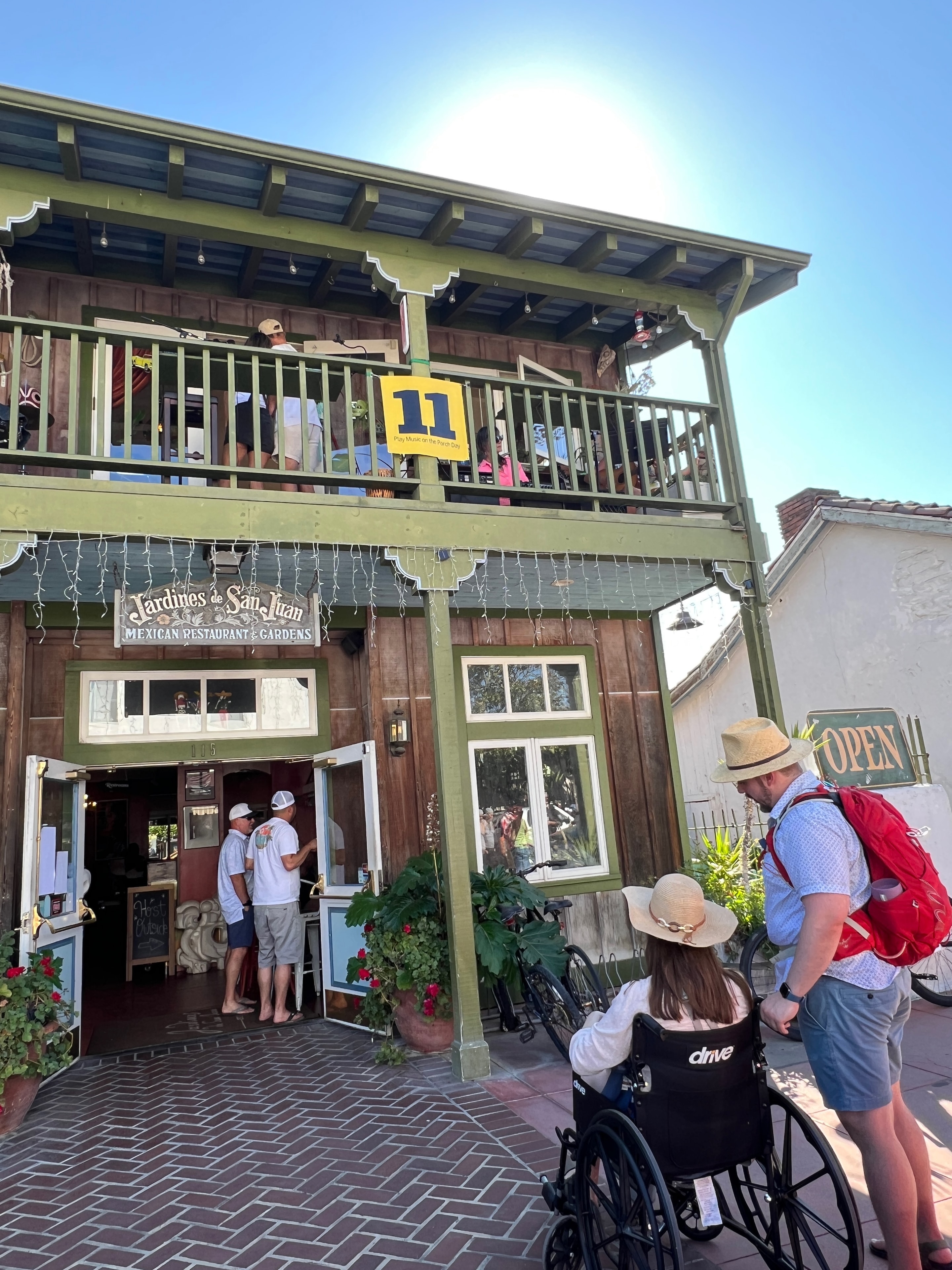 Jardines de San Juan Mexican Restaurant with Play Music on the Porch Day number 11 sign on the balcony
